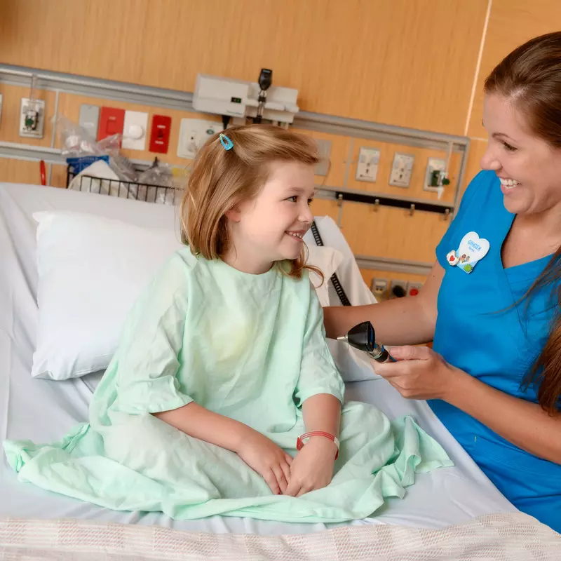 A girl smiles with her nurse