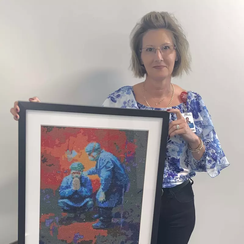 Claudia Colache Klein holding one of her art pieces