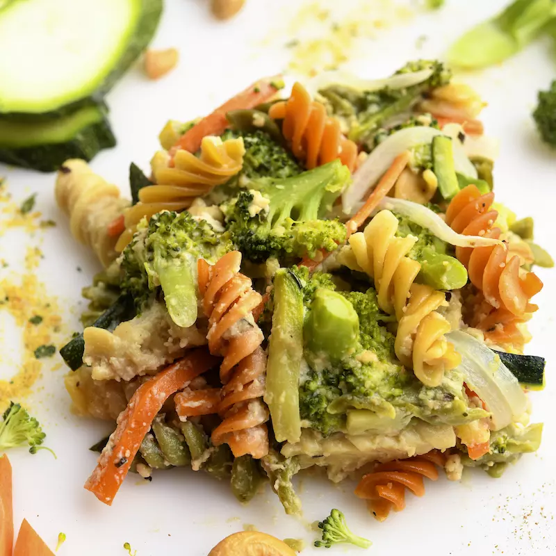 Square of veggie-pasta casserole with zucchini garnish