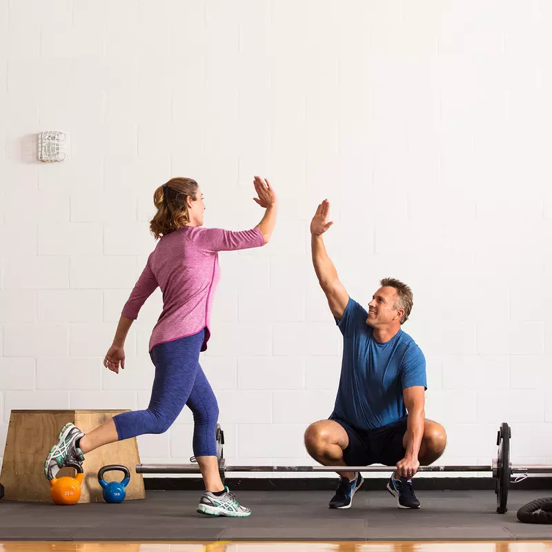 A couple giving each other high five while working out.