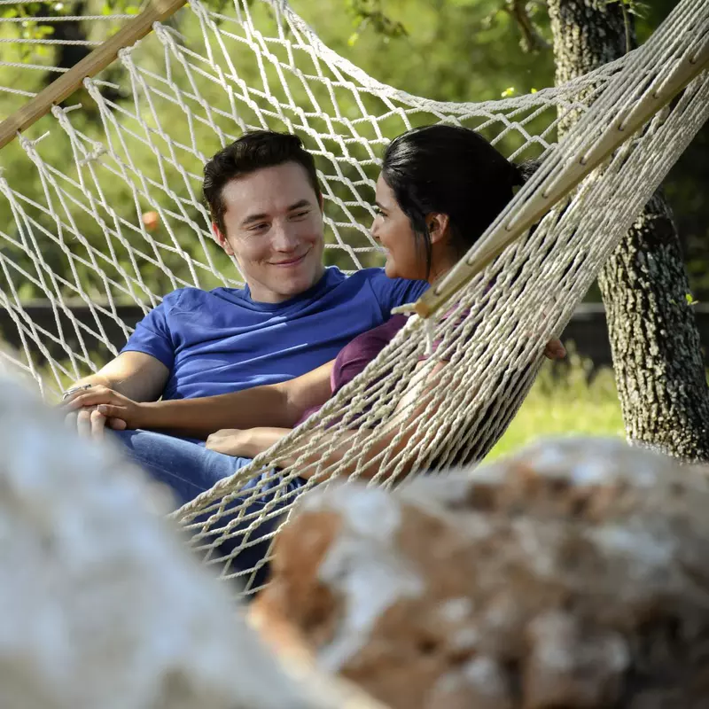 Couple sitting in a hammock outdoors.