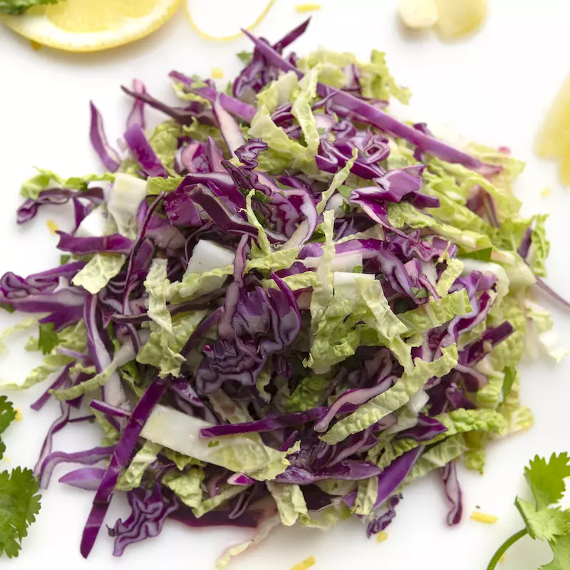 Mound of napa cabbage salad with cilantro garnish