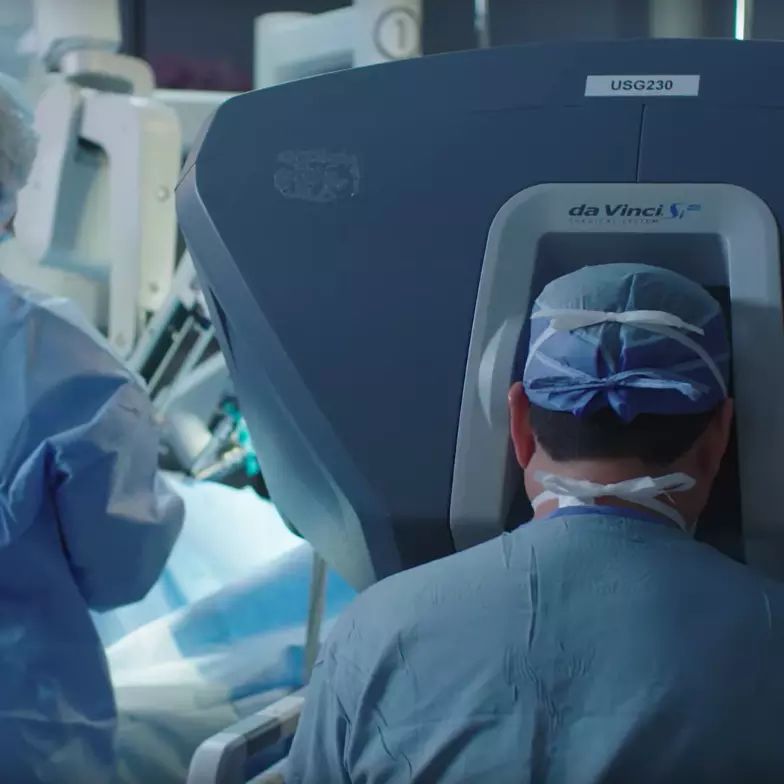 Surgeon and nurse around the da Vinci Robot in a surgery room