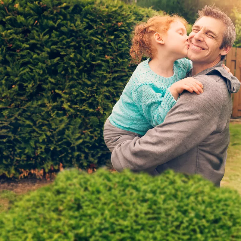 daughter hugging and kissing father outside