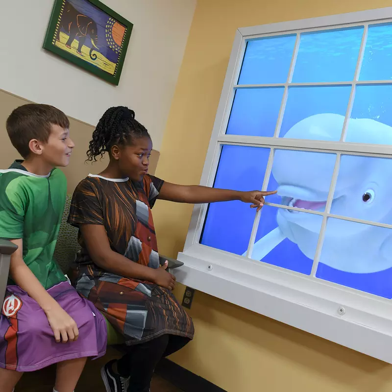 AdventHealth for Children looking at Disney Team of Heroes Magic Window
