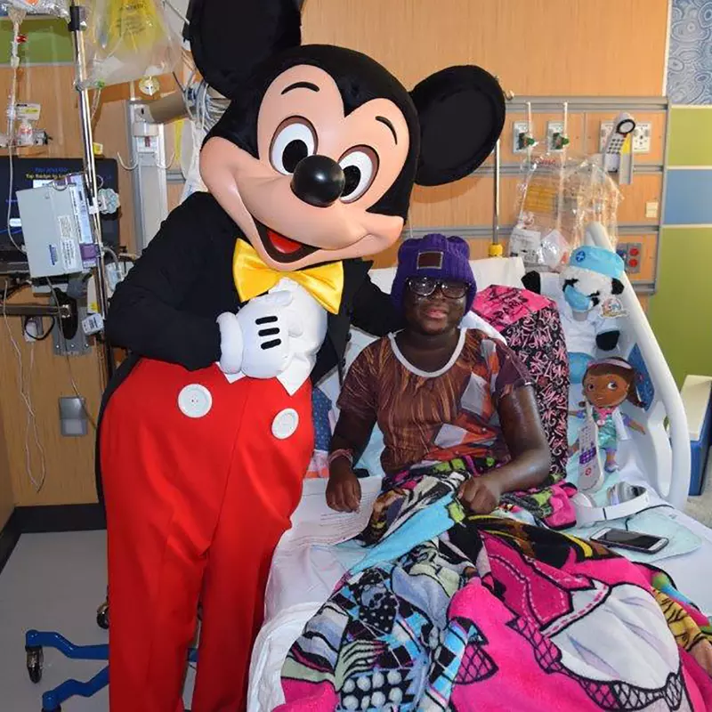 Mickey Mouse with a young patient at AdventHealth for Children.