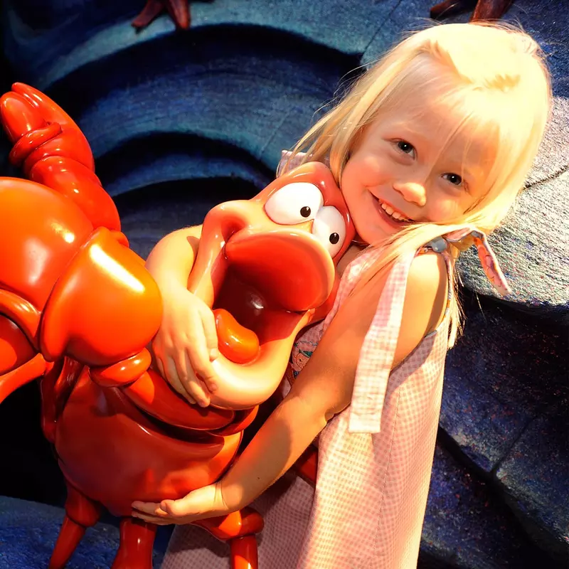 Girl hugging Sebastian the Crab at AdventHealth for Children