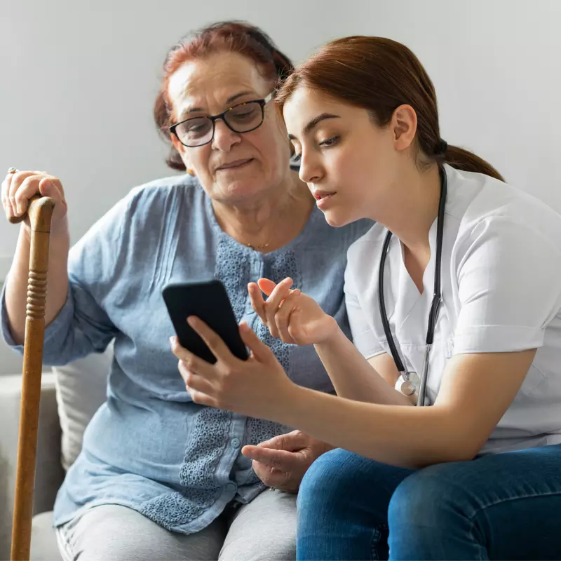 Doctor showing a senior woman something on a smart phone.