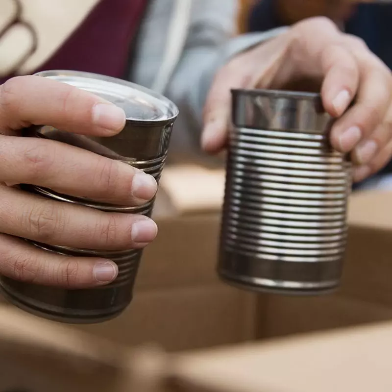 A food bank volunteer puts canned food into a box
