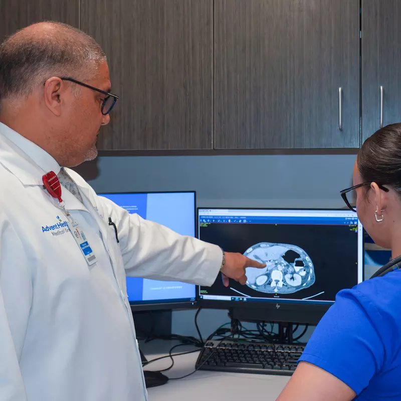 Dr. Norbert Garcia-Henriquez analyzes a patients scan with a team member at the AdventHealth Cancer Institute.