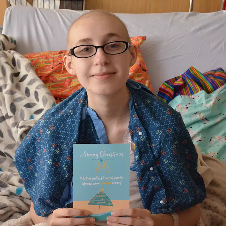 A cancer patient holding a card