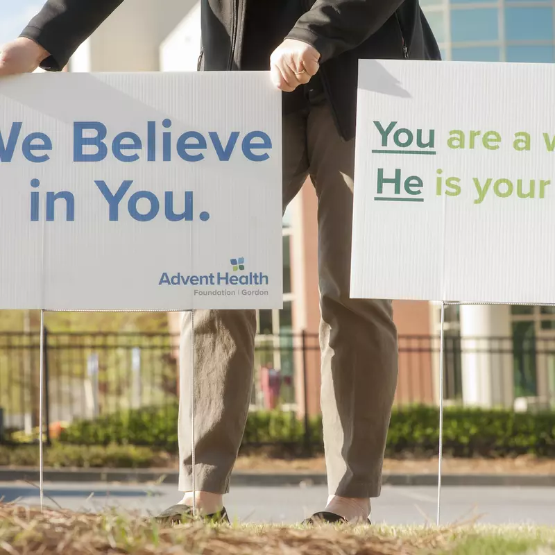 Man holding a sign saying "We believe in you".