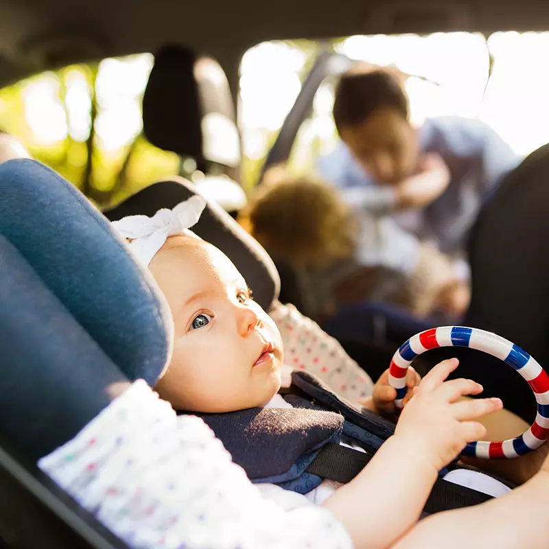 Baby in carseat holding toy