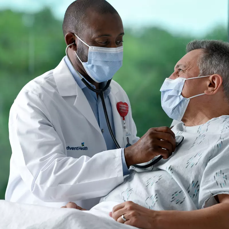 Masked doctor with masked patient in Emergency Room