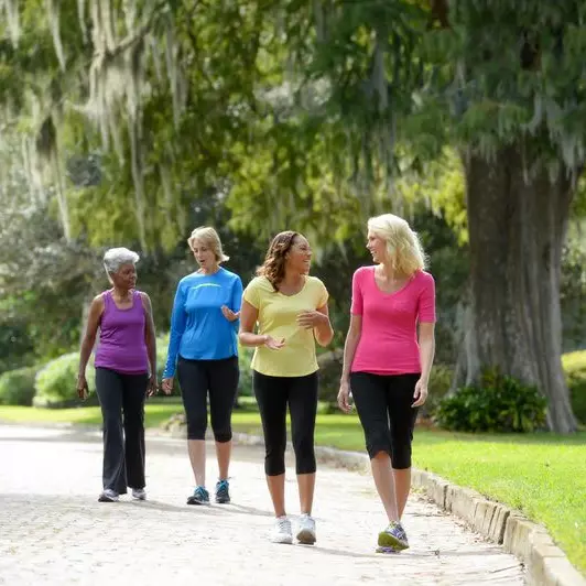 A group of mature ladies walking outdoors while chit-chatting