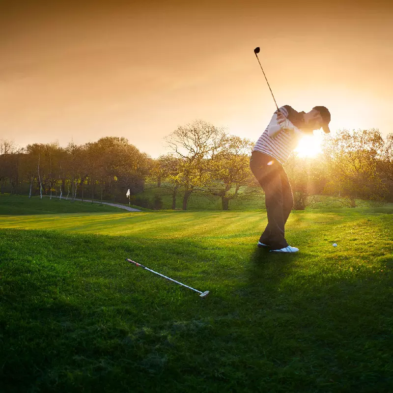 A golfer playing during sunrise