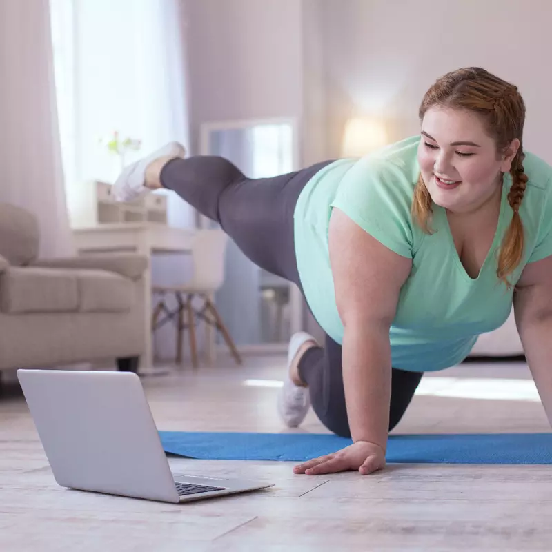 A woman doing a yoga session in front of her computer