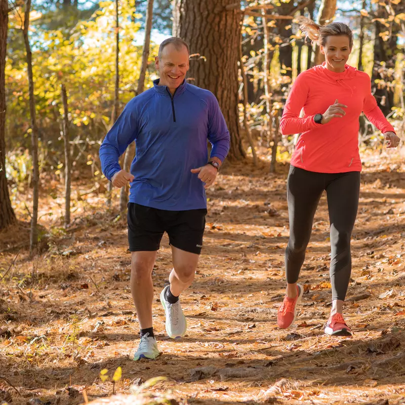 A Middle Aged Couple Goes For a Jog Through a Wooded Trail.