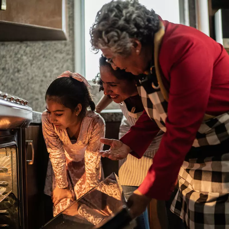 Grandmother, Mother and Child looking into an oven.