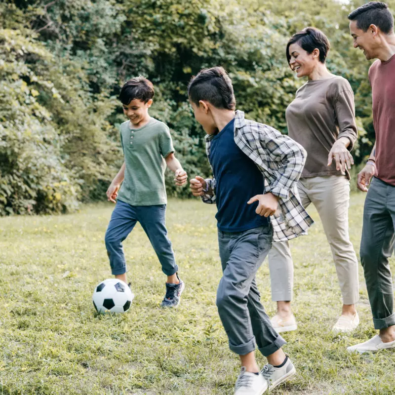 Family playing soccer together at home.