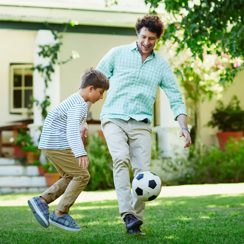 Father and son playing soccer.