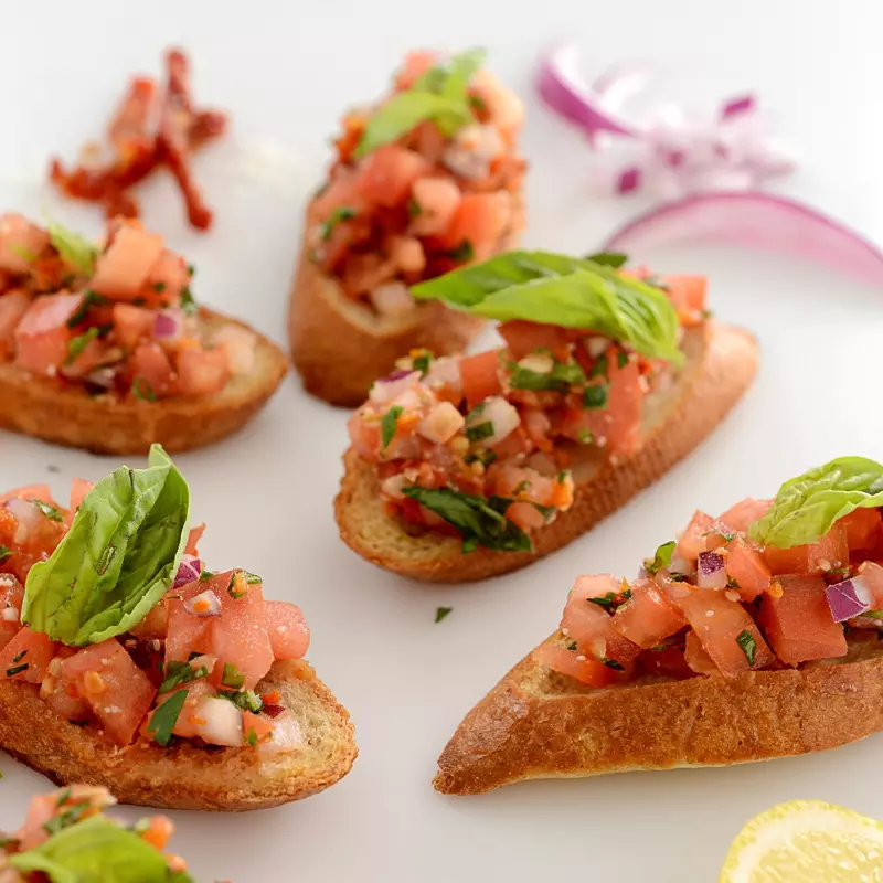 toasted slices of bread, topped with chopped tomato, garlic, onion and basil