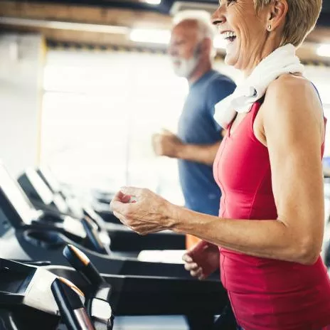 A Senior Couple at the Gym Running on Treadmills