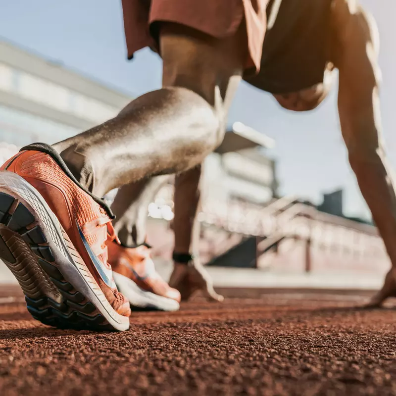 A low-angle shot of a male runner about to start a race