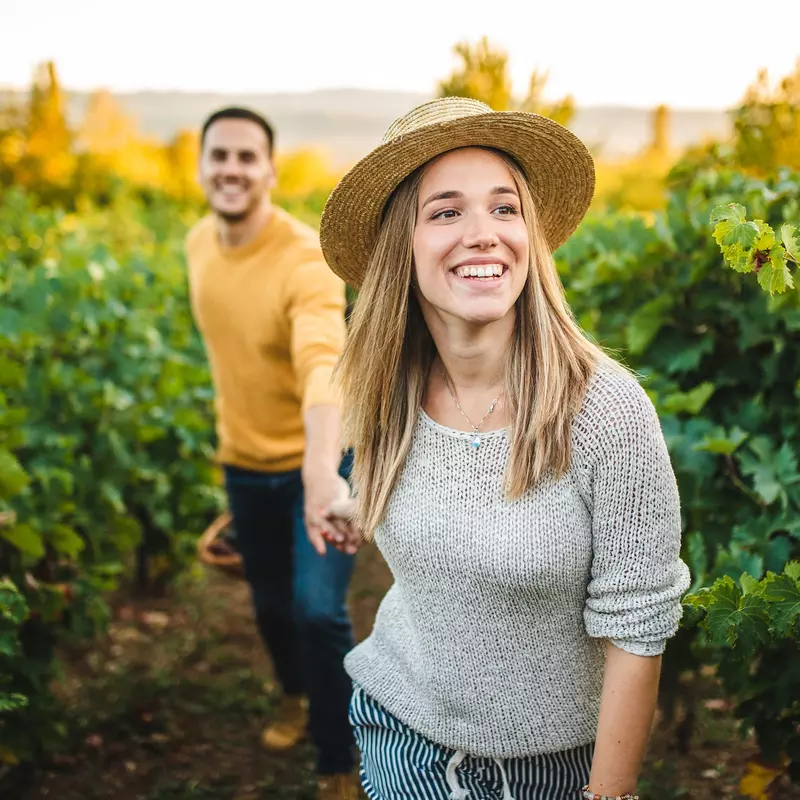 Happy couple walking through a vineyard