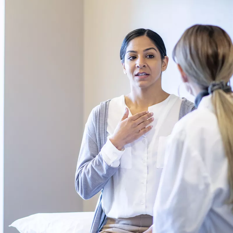 A young woman speaks to her female doctor.