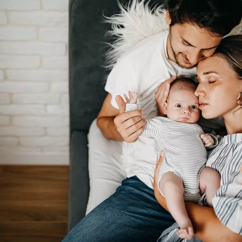 A Mother and Father Hug Their Newborn Baby