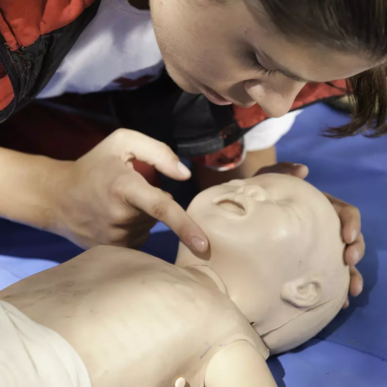 Person preparing to practice cpr on a mannequin