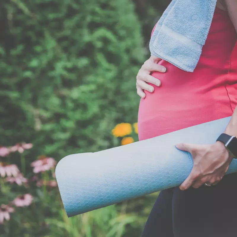 pregnant woman carrying yoga mat
