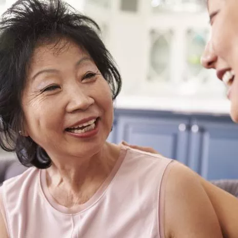 A Senior Woman Speaks to Her Daughter on a Couch at Home