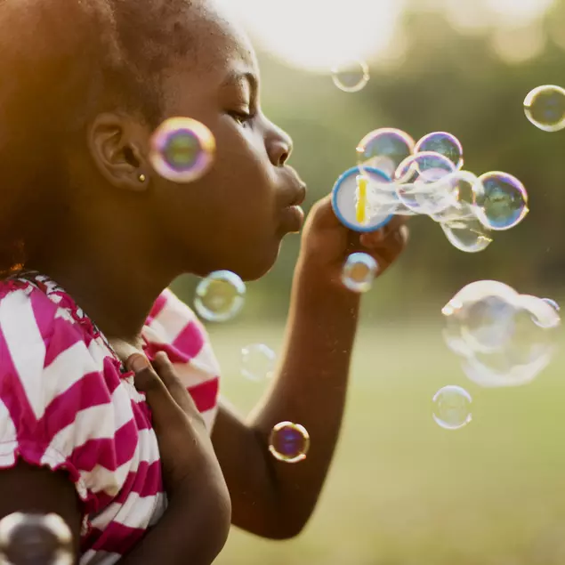 young girl playing with bubbles