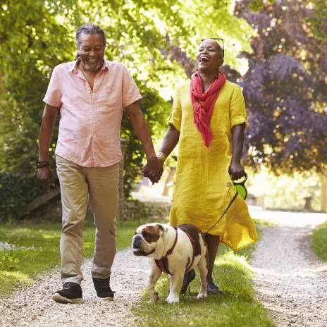 A Couple Walks Their Dog Through the Park