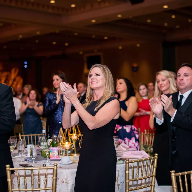 A group of people clapping at a gala night.
