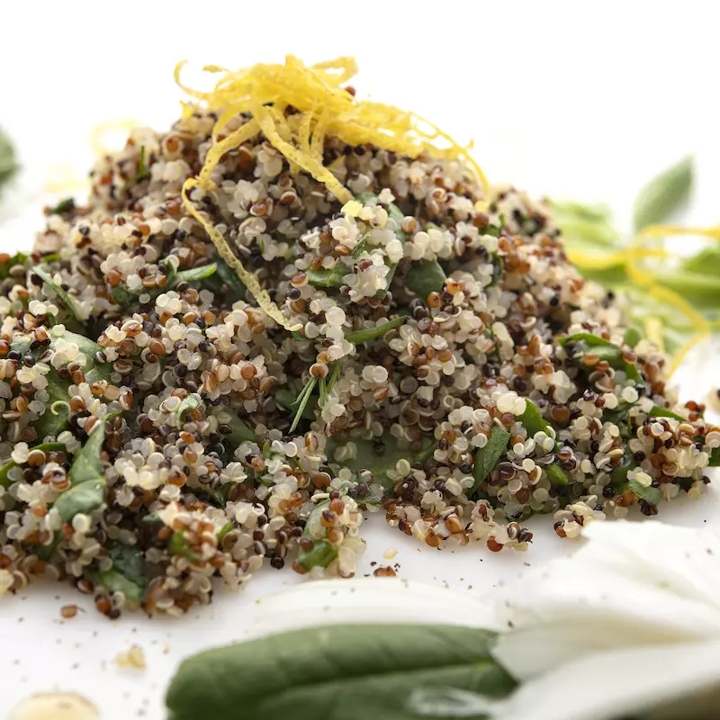 Mound of quinoa salad with green garnishes