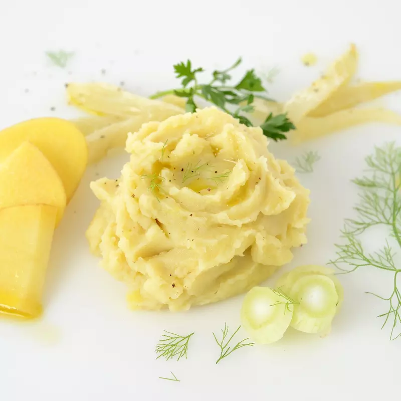 a pile of mashed fennel and mashed potatoes, with sliced potatoes on the side