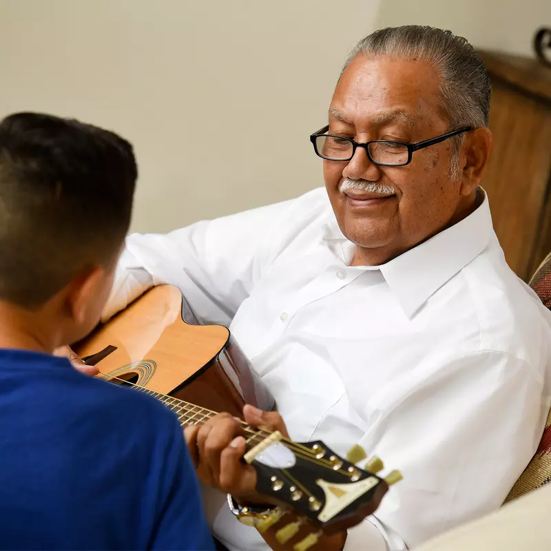 Grandfather teaching his grandson guitar.