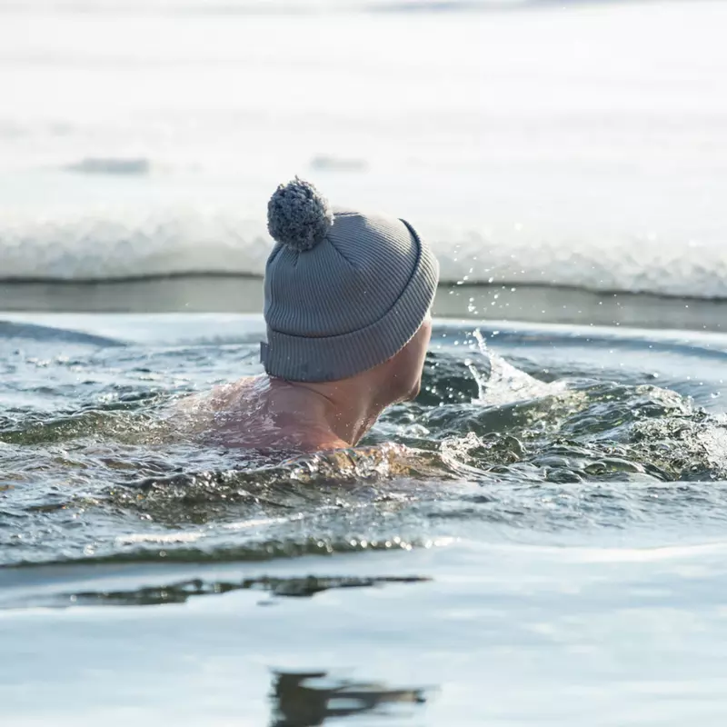 A man taking a swim in cold water.