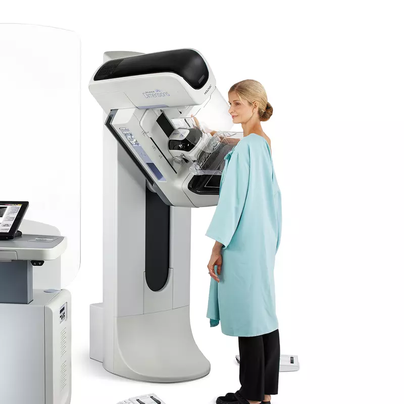 A woman getting a mammogram done with a 3D mammography machine