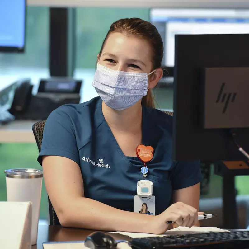 An AdventHealth employee working at a computer. 