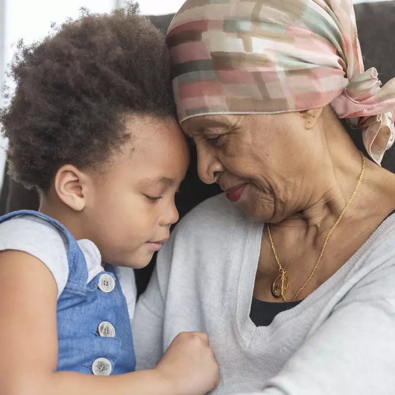 A cancer survivor hugs her grandchild.