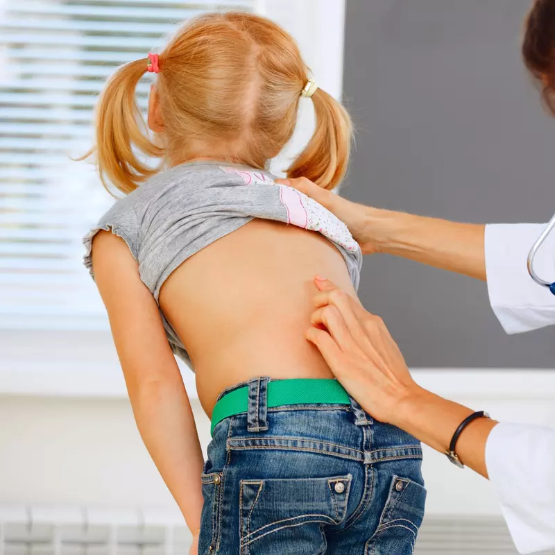 A child getting her spine examined.