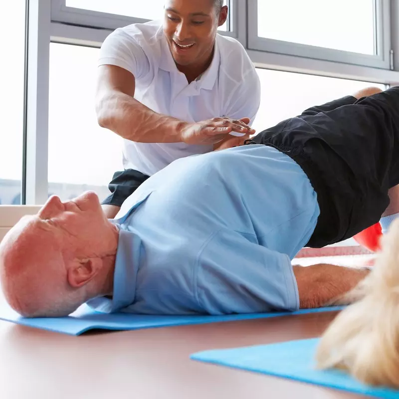 A couple does stretching and strengthening exercises with a physical therapist. 