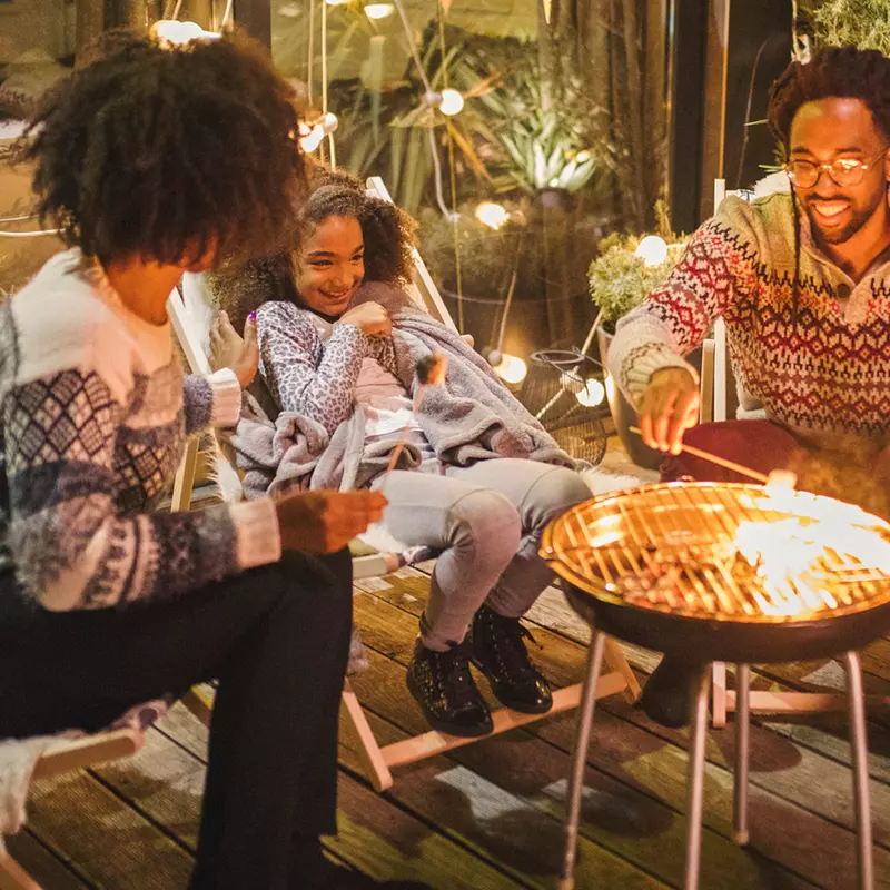 A family roasting marshmallows outside.