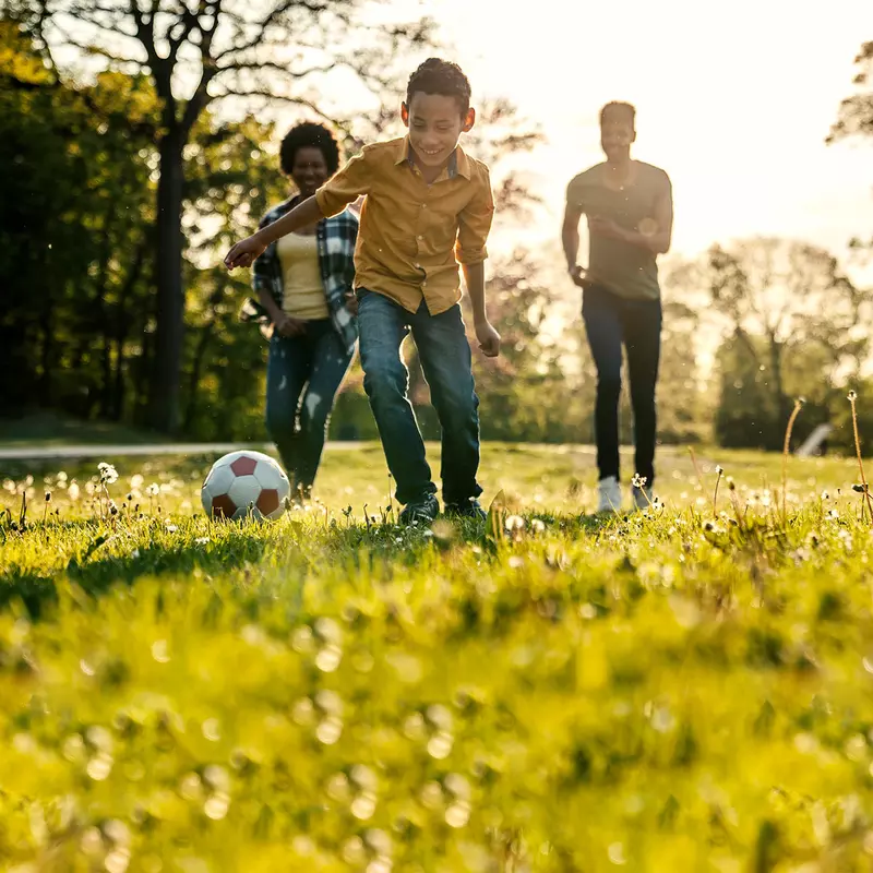 A family playing soccer together outdoors.