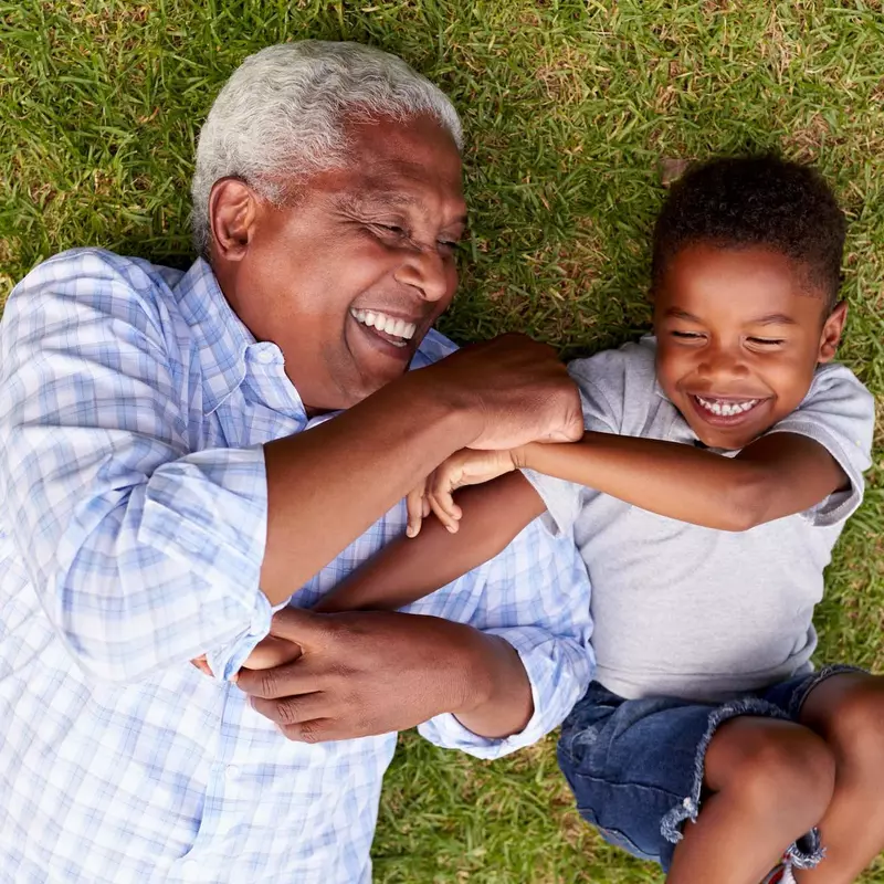 A grandfather playing with his young grandson.