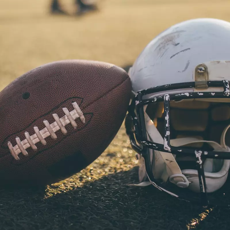 A helmet and a football on a field.